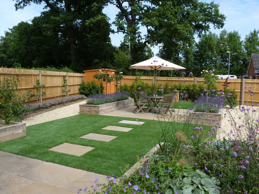 This is an example of a mid-sized contemporary backyard full sun garden in Hertfordshire with natural stone pavers and a container garden.