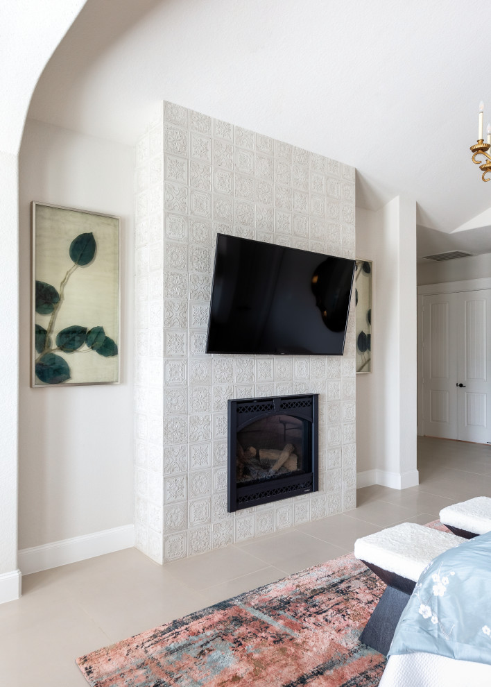 ヒューストンにある広い地中海スタイルのおしゃれな主寝室 (白い壁、磁器タイルの床、標準型暖炉、タイルの暖炉まわり、白い床、三角天井) のインテリア