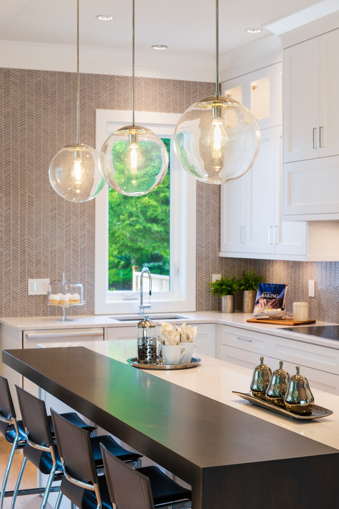 Open concept kitchen - mid-sized transitional l-shaped light wood floor and beige floor open concept kitchen idea in Vancouver with an undermount sink, shaker cabinets, white cabinets, quartz countertops, gray backsplash, mosaic tile backsplash, paneled appliances, an island and gray countertops