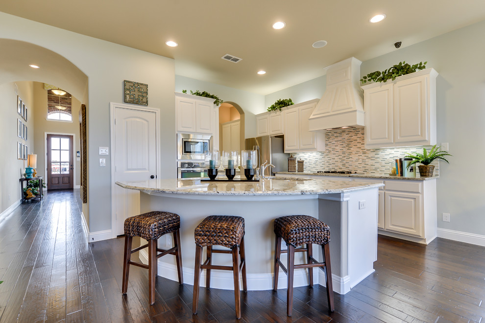 Inspiration for a contemporary kitchen in Dallas with white cabinets, granite benchtops, stainless steel appliances, dark hardwood floors and with island.