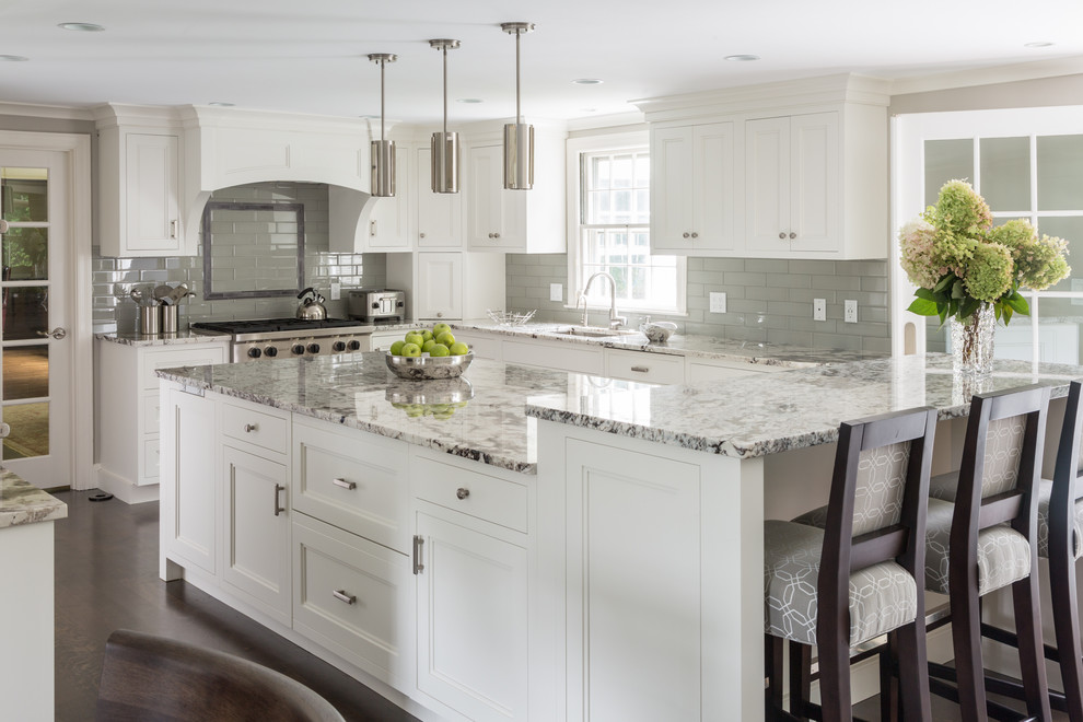 Design ideas for a large traditional l-shaped kitchen in Boston with an undermount sink, recessed-panel cabinets, white cabinets, grey splashback, subway tile splashback, stainless steel appliances, dark hardwood floors, with island and brown floor.