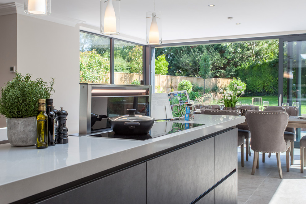Design ideas for a contemporary l-shaped open plan kitchen in Oxfordshire with flat-panel cabinets, grey cabinets, quartzite benchtops, stainless steel appliances, with island, grey floor and white benchtop.