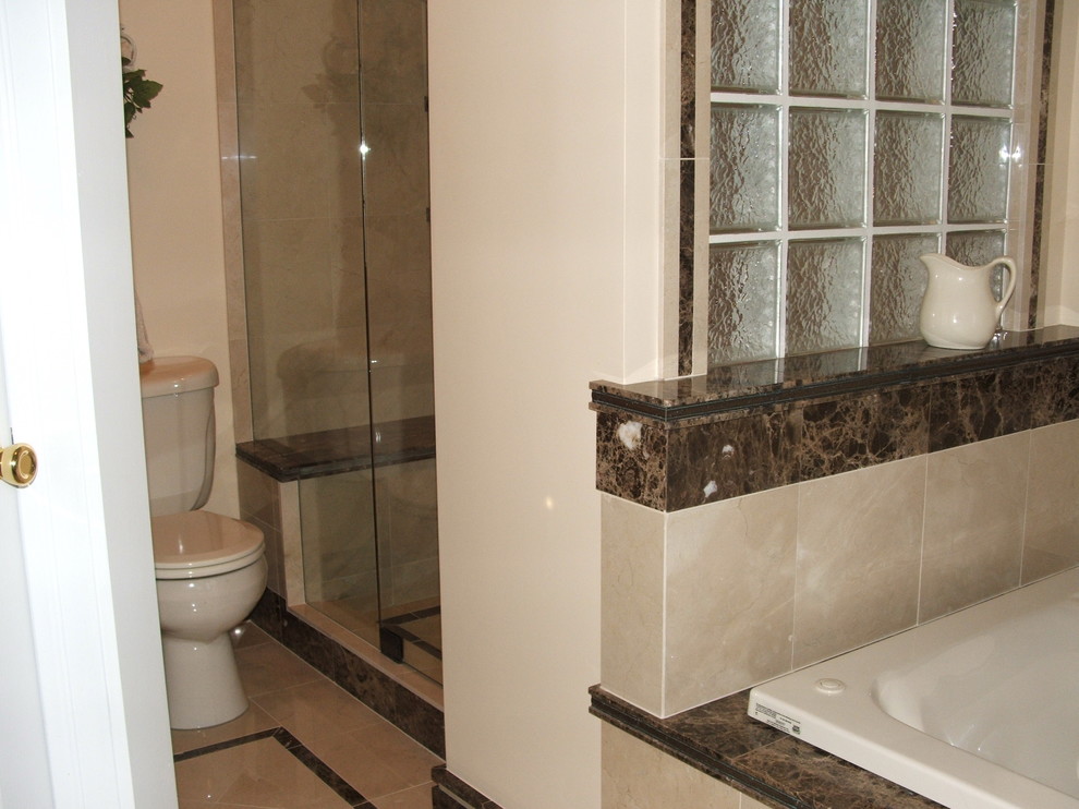 Mid-sized transitional master beige tile and porcelain tile porcelain tile and beige floor drop-in bathtub photo with a two-piece toilet, beige walls, granite countertops, a hinged shower door, raised-panel cabinets, dark wood cabinets and an undermount sink