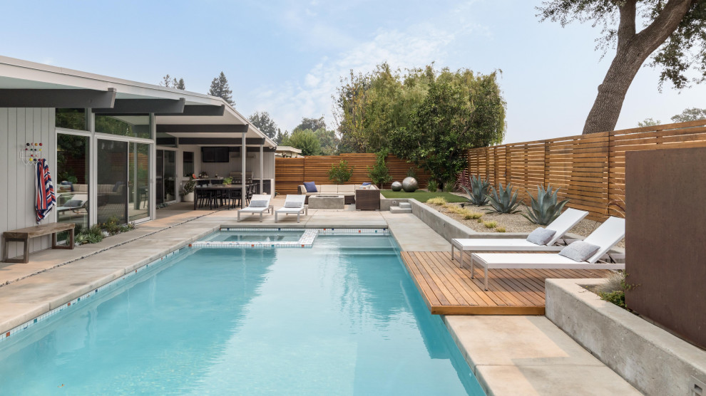 Midcentury backyard rectangular pool in Sacramento with a hot tub and concrete slab.