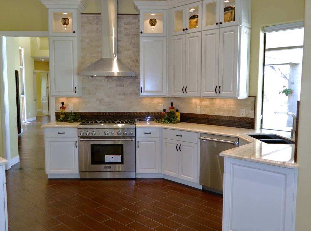 Inspiration for a mid-sized transitional u-shaped dark wood floor eat-in kitchen remodel in Phoenix with a double-bowl sink, raised-panel cabinets, white cabinets, granite countertops, beige backsplash, ceramic backsplash, stainless steel appliances and an island