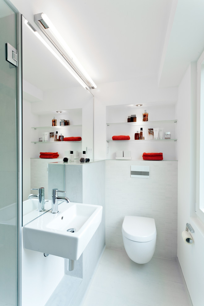 Inspiration for a mid-sized contemporary bathroom in Cologne with open cabinets, a wall-mount toilet, white tile, mosaic tile, white walls and a wall-mount sink.