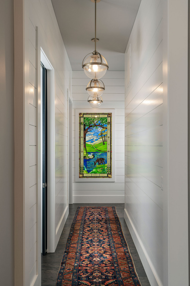 This is an example of a mid-sized transitional hallway in Other with white walls, dark hardwood floors and brown floor.