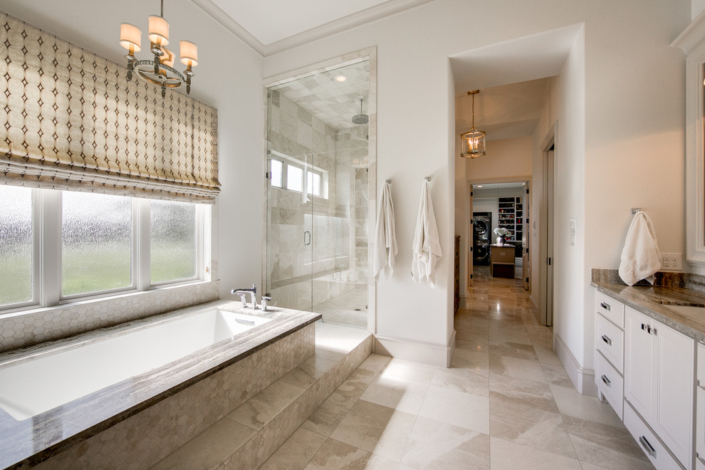 Photo of an expansive transitional master bathroom in Dallas with shaker cabinets, white cabinets, an undermount tub, a double shower, a two-piece toilet, beige tile, ceramic tile, white walls, ceramic floors, an undermount sink, granite benchtops, beige floor and a hinged shower door.