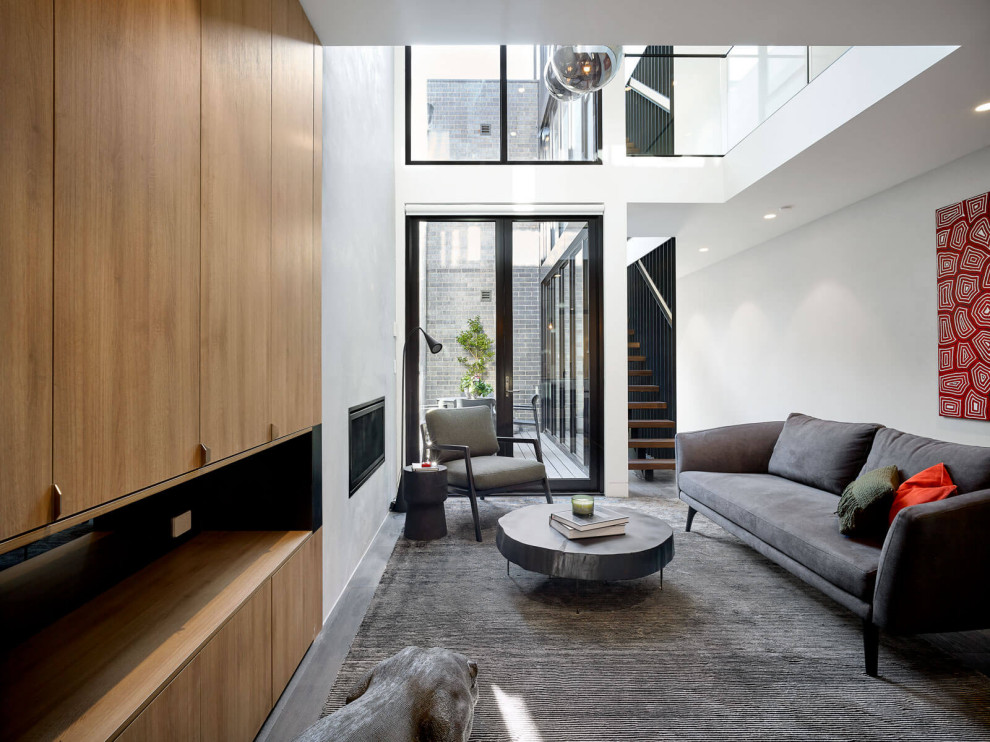 Medium sized modern open plan living room in Melbourne with yellow walls, dark hardwood flooring, all types of fireplace, a concrete fireplace surround, a concealed tv, brown floors, all types of ceiling and all types of wall treatment.
