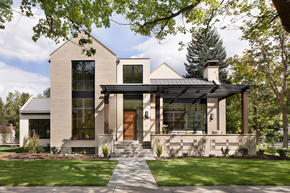Idées déco pour une façade de maison beige contemporaine à un étage avec un toit en métal, un revêtement mixte, un toit à deux pans et un toit gris.