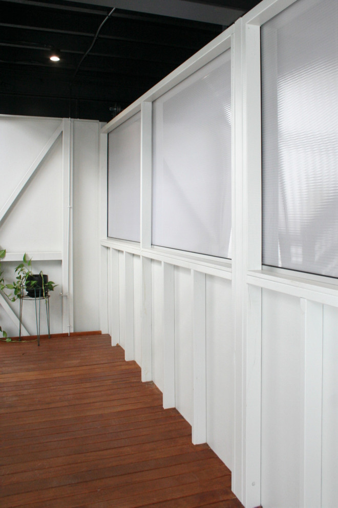 Imagen de recibidores y pasillos modernos de tamaño medio con paredes blancas, suelo de madera en tonos medios, suelo marrón, vigas vistas y panelado