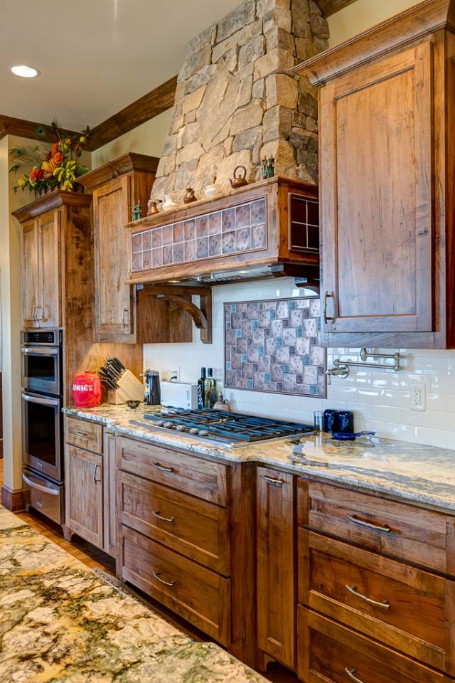 Inspiration for a mid-sized country single-wall separate kitchen in Other with recessed-panel cabinets, dark wood cabinets, granite benchtops, white splashback, stone tile splashback, stainless steel appliances, light hardwood floors, with island and brown floor.