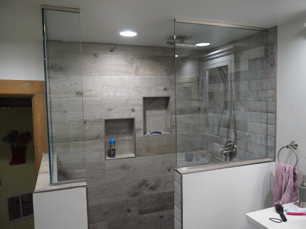 Mid-sized transitional 3/4 bathroom in Other with shaker cabinets, white cabinets, a corner shower, a two-piece toilet, gray tile, ceramic tile, grey walls, laminate floors, an undermount sink, engineered quartz benchtops, grey floor and an open shower.