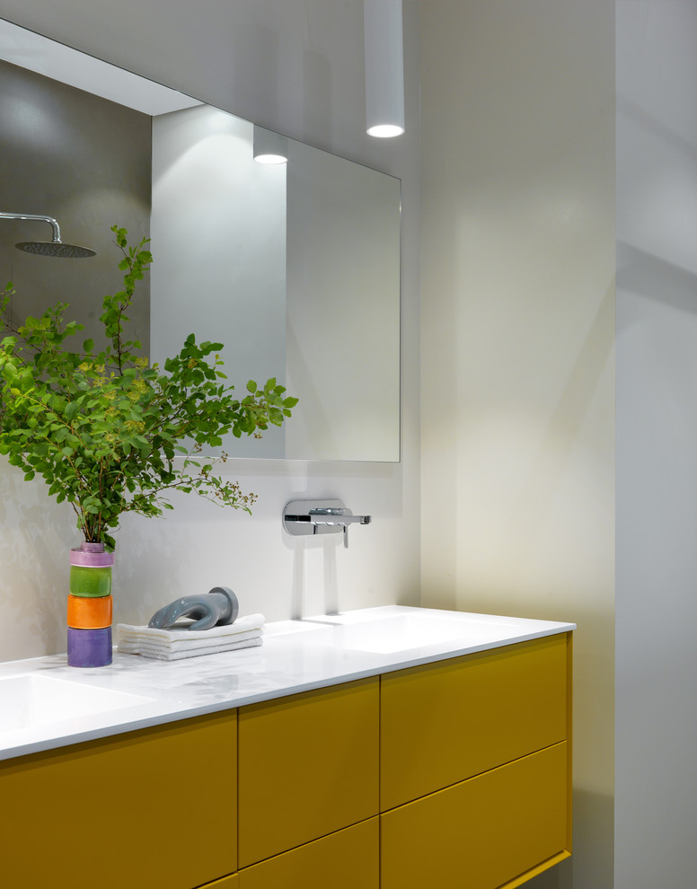 This is an example of a mid-sized contemporary kids bathroom in Moscow with flat-panel cabinets, yellow cabinets, white tile, beige walls, a trough sink and white benchtops.