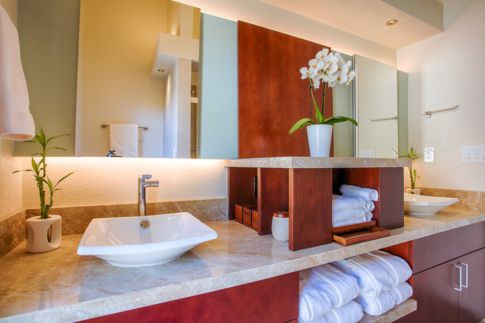 Small transitional beige tile and porcelain tile porcelain tile and beige floor alcove bathtub photo in Phoenix with flat-panel cabinets, medium tone wood cabinets, a one-piece toilet, beige walls, a vessel sink and granite countertops