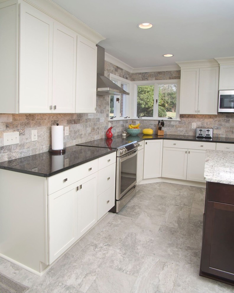 Example of a large transitional u-shaped ceramic tile and gray floor eat-in kitchen design with a farmhouse sink, white cabinets, granite countertops, multicolored backsplash, subway tile backsplash, stainless steel appliances, an island and shaker cabinets