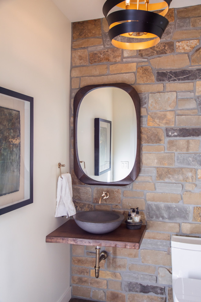 Inspiration for a mid-sized transitional powder room in Other with open cabinets, dark wood cabinets, a two-piece toilet, multi-coloured tile, stone tile, white walls, medium hardwood floors, a vessel sink, wood benchtops, brown floor and brown benchtops.