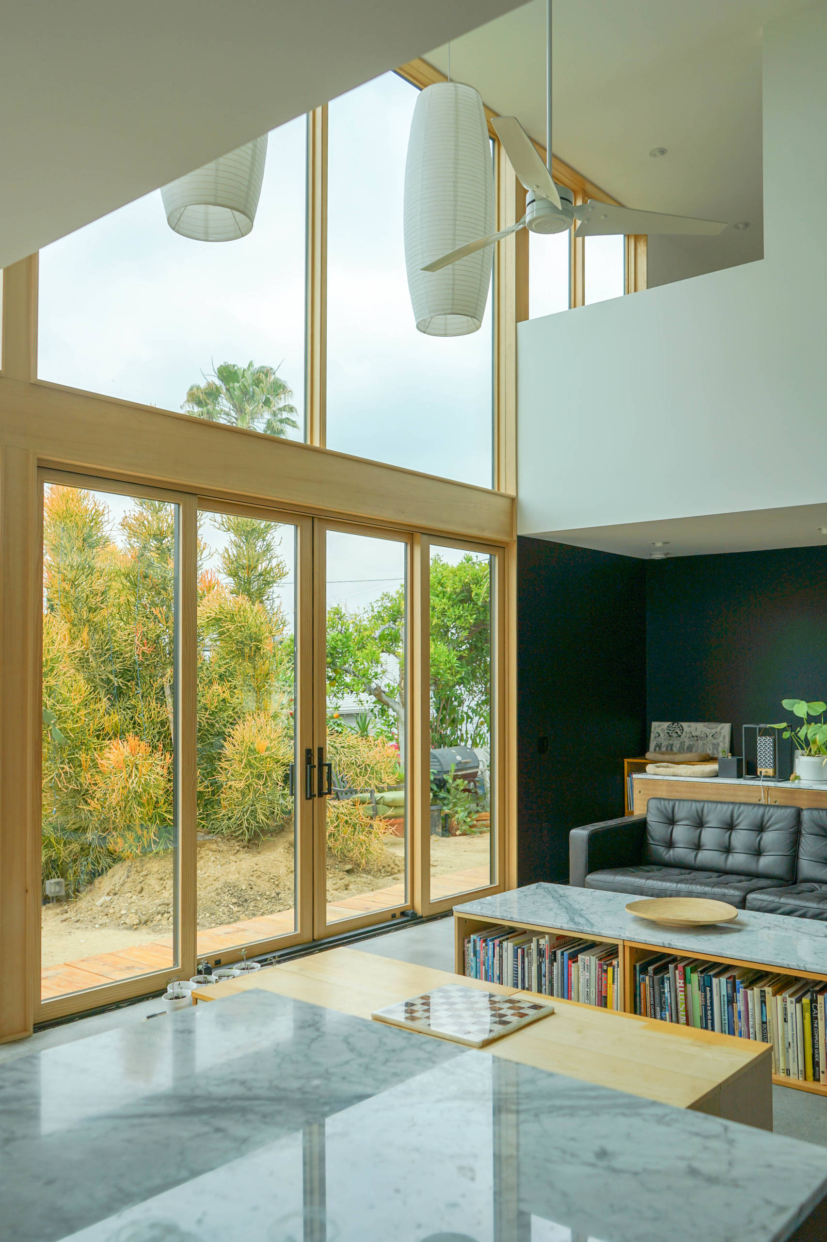 This ADU's Great Room contains expansive windows and doors which open and with an open second floor it provides natural light to fill the room.