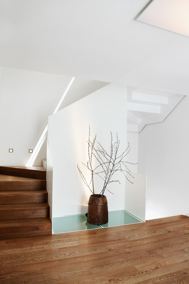 Design ideas for a mid-sized contemporary wood curved staircase in Munich with wood risers.