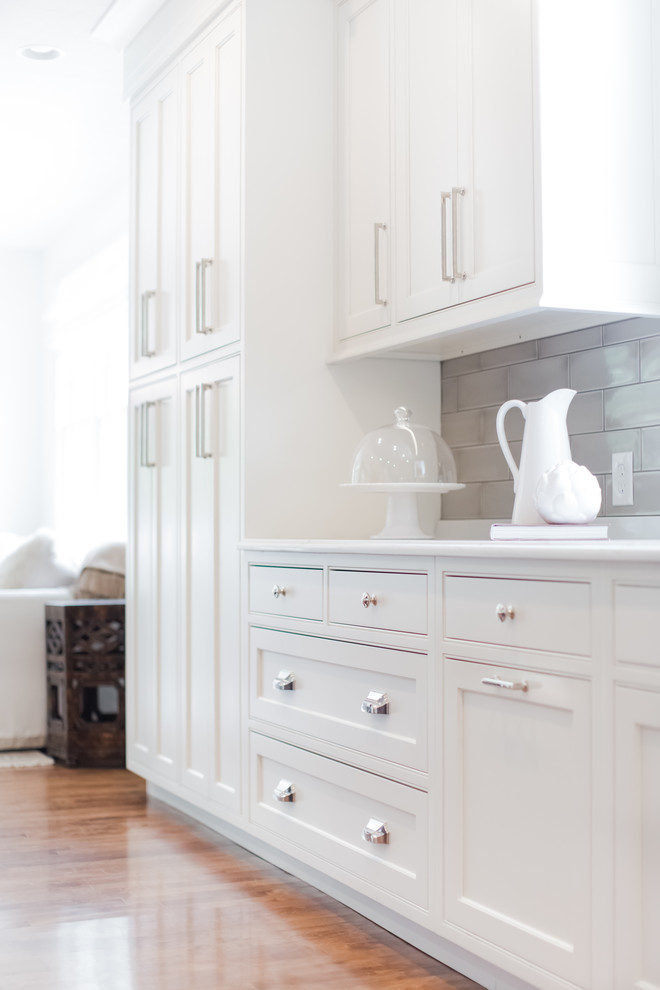 Large arts and crafts galley medium tone wood floor and brown floor open concept kitchen photo in Indianapolis with an undermount sink, shaker cabinets, white cabinets, quartzite countertops, gray backsplash, subway tile backsplash, paneled appliances and an island