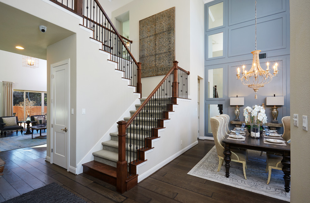 Photo of a mid-sized country carpeted u-shaped staircase in Austin with carpet risers and metal railing.