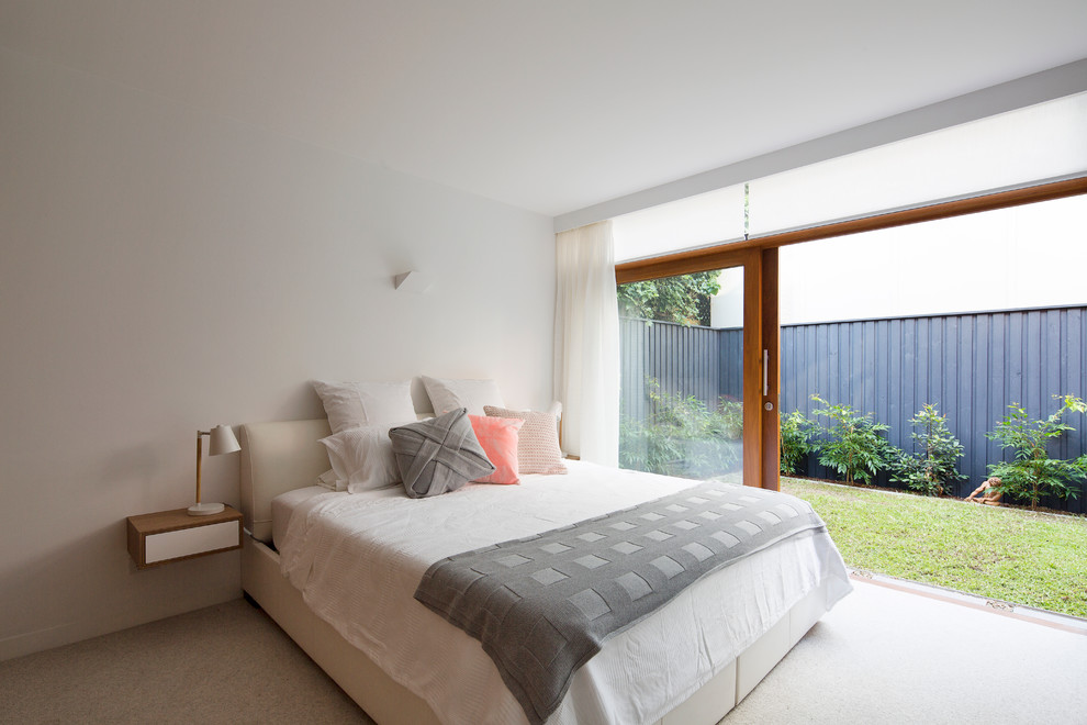 This is an example of a mid-sized contemporary master bedroom in Sydney with white walls, carpet and no fireplace.