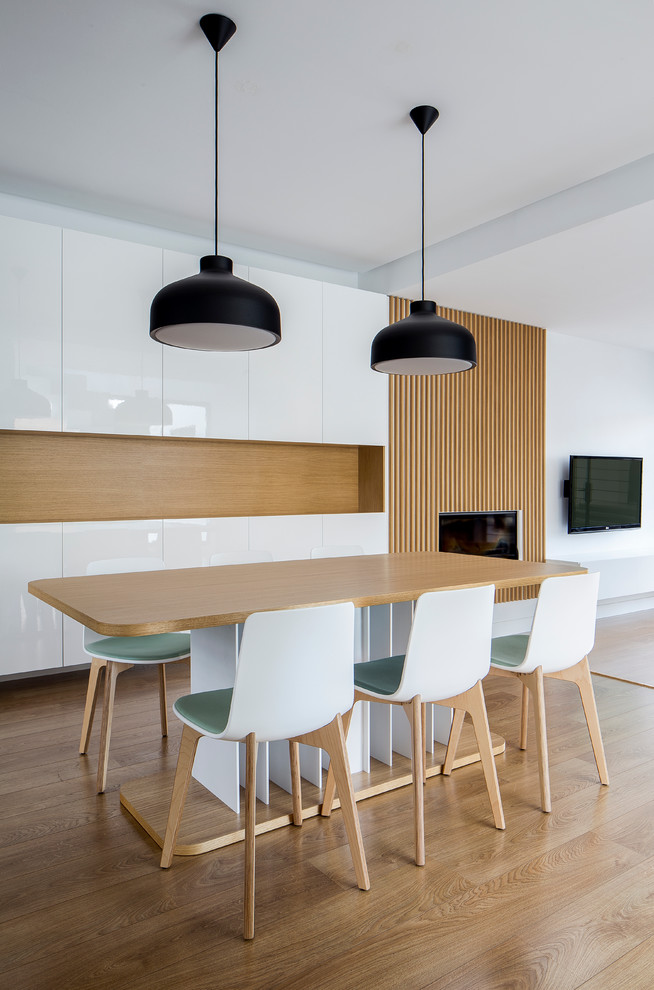 Diseño de comedor clásico renovado de tamaño medio abierto con paredes blancas, suelo de madera en tonos medios y todas las chimeneas