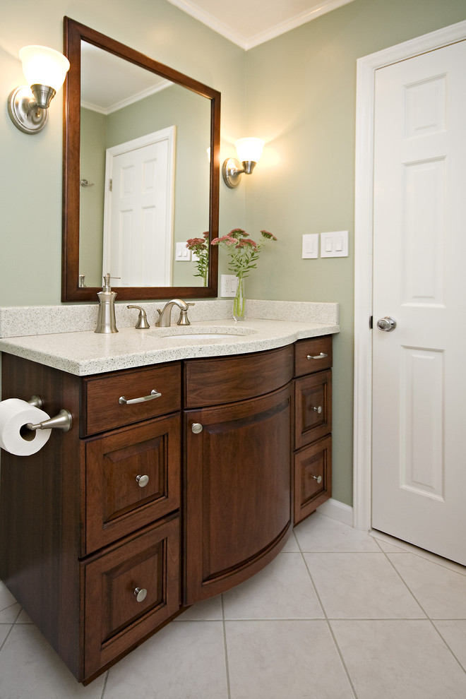 This is an example of a small transitional kids bathroom in Raleigh with raised-panel cabinets, dark wood cabinets, an alcove tub, a shower/bathtub combo, a one-piece toilet, beige tile, cement tile, green walls, ceramic floors, an undermount sink, concrete benchtops, beige floor, a shower curtain and white benchtops.