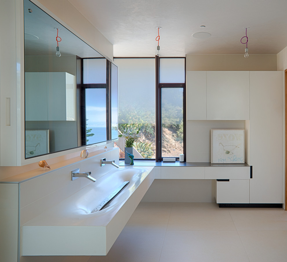 Design ideas for a large modern master bathroom in San Francisco with flat-panel cabinets, white cabinets, white tile, ceramic floors, a trough sink, concrete benchtops, beige floor and brown benchtops.