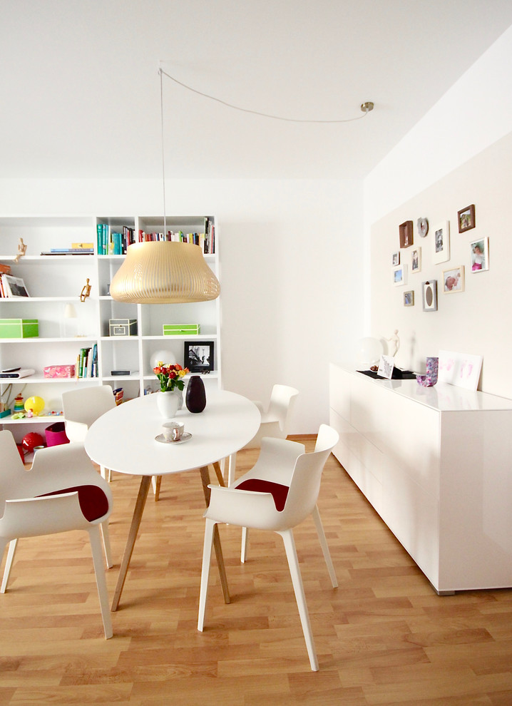 Small eclectic open plan dining in Frankfurt with white walls, medium hardwood floors, no fireplace and brown floor.