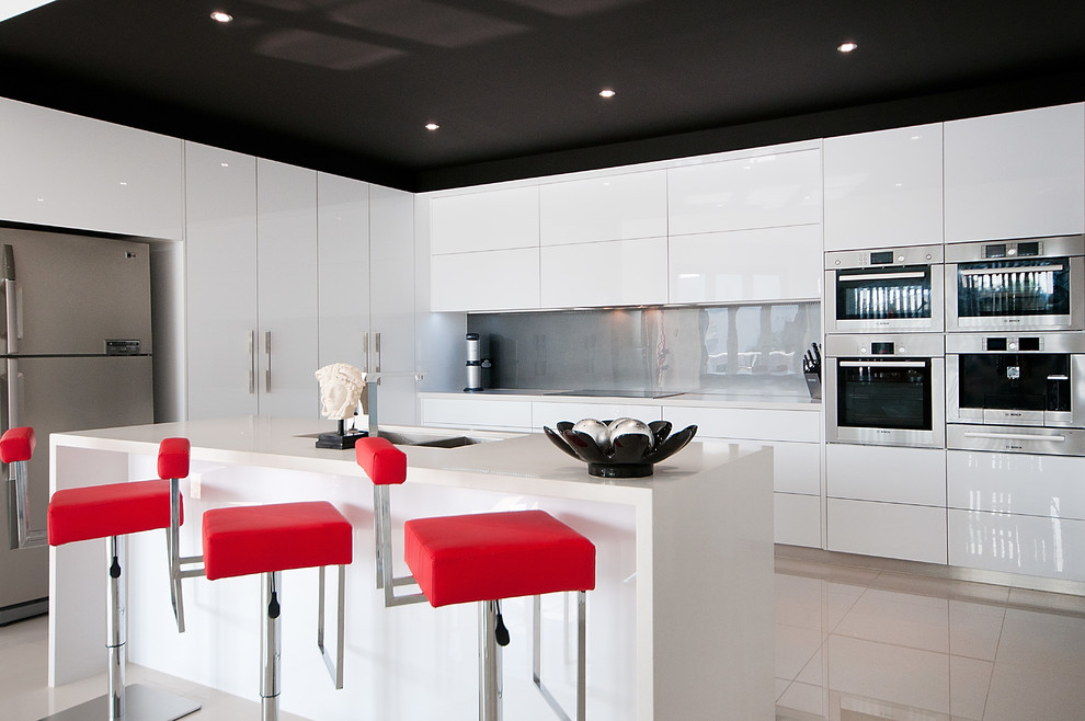 Design ideas for a large modern single-wall separate kitchen in Gold Coast - Tweed with an undermount sink, flat-panel cabinets, white cabinets, quartz benchtops, grey splashback, glass sheet splashback, stainless steel appliances, ceramic floors and with island.