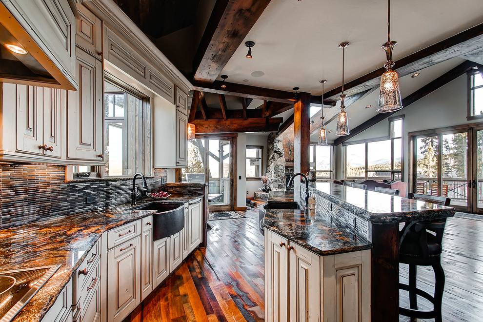 Example of a transitional open concept kitchen design in Denver with a farmhouse sink, raised-panel cabinets, beige cabinets, brown backsplash and paneled appliances