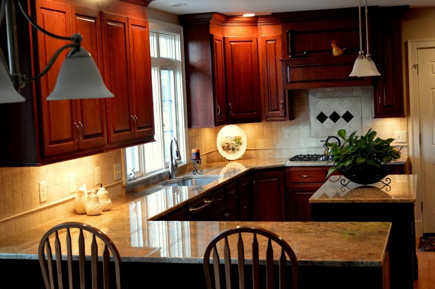 Kitchen - mid-sized transitional u-shaped medium tone wood floor kitchen idea in Boston with an undermount sink, raised-panel cabinets, medium tone wood cabinets, granite countertops and an island