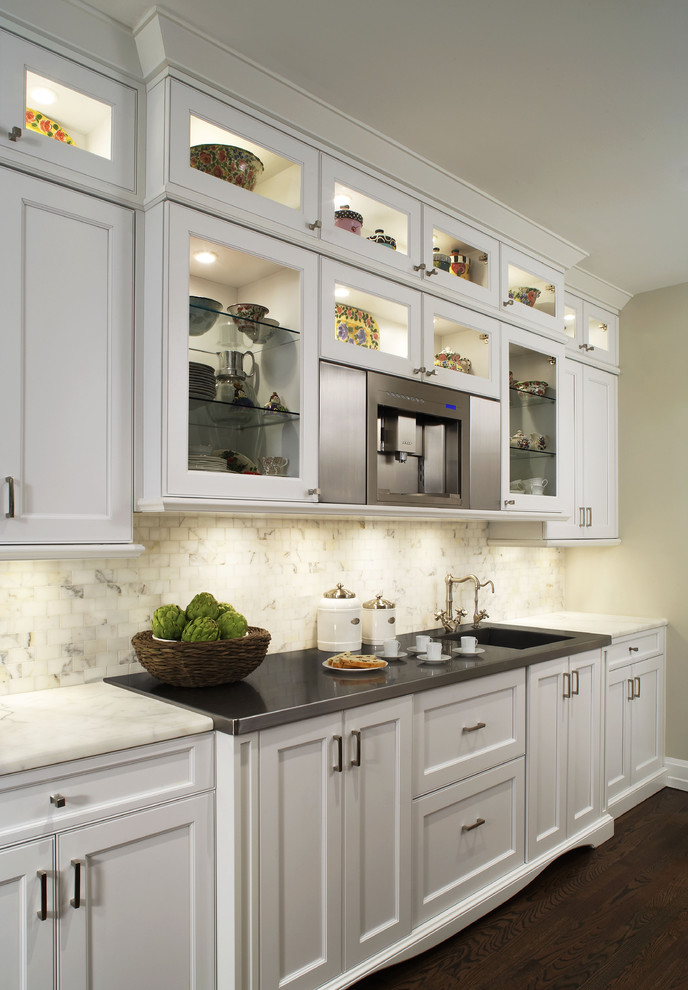 This is an example of a contemporary kitchen in Detroit with glass-front cabinets, white cabinets and white splashback.