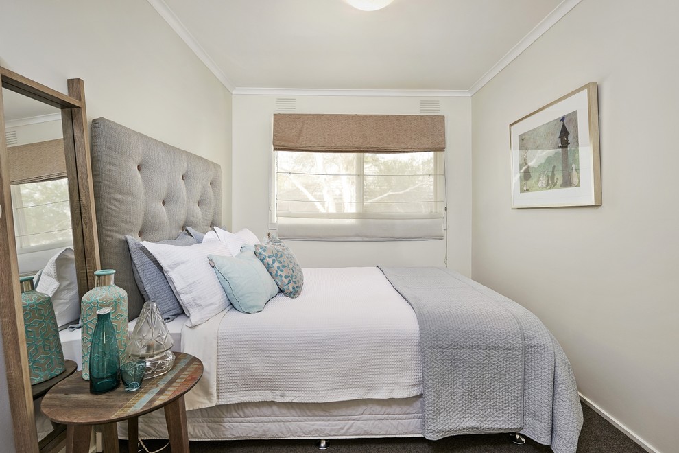 Small transitional guest bedroom in Melbourne with white walls and carpet.