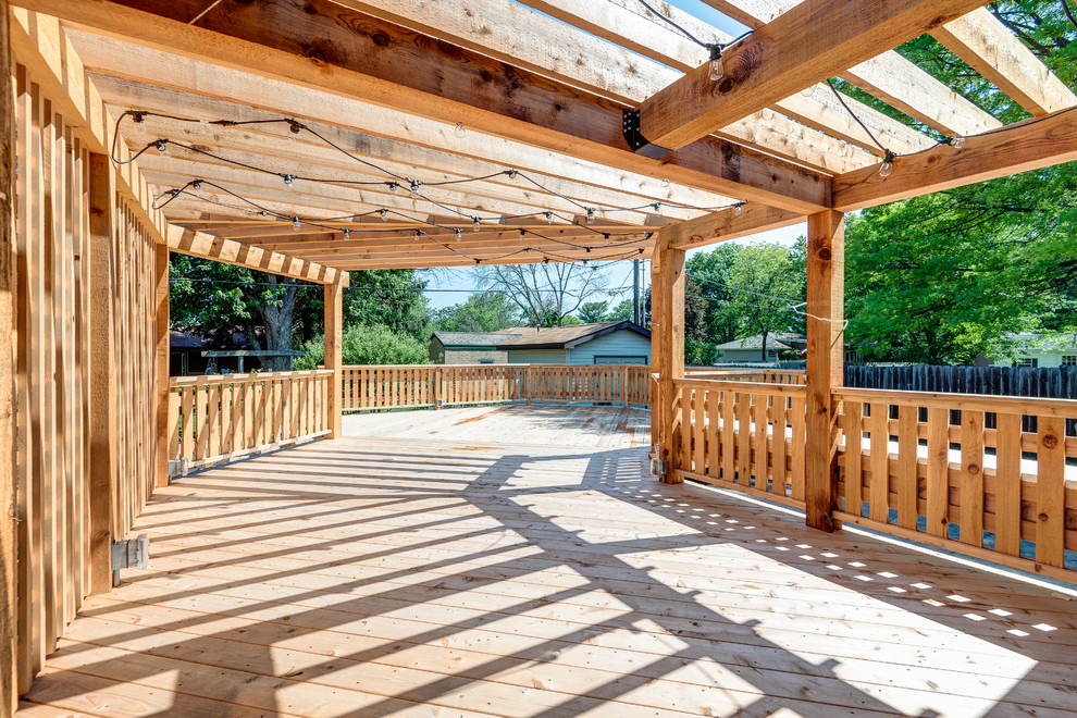 Large transitional backyard deck photo in Chicago with a pergola