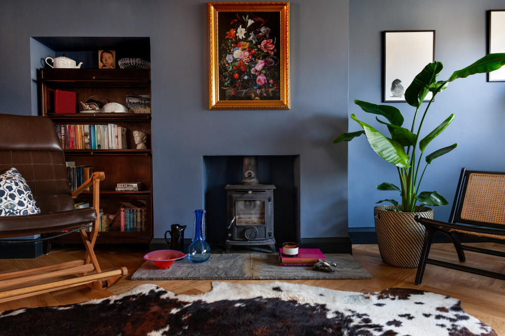 На фото: открытая гостиная комната среднего размера в стиле фьюжн с синими стенами и печью-буржуйкой