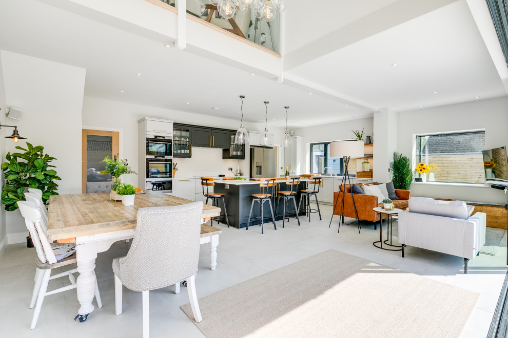 This is an example of a medium sized urban open plan kitchen in Sussex with an integrated sink, shaker cabinets, grey cabinets, quartz worktops, stainless steel appliances, porcelain flooring, an island, white floors and white worktops.