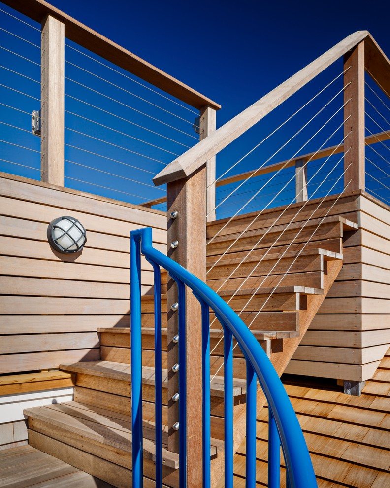 Photo of a small beach style wood l-shaped staircase in New York with wood risers and metal railing.