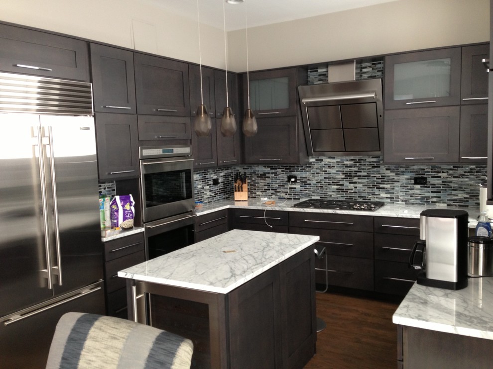 This is an example of a mid-sized modern u-shaped eat-in kitchen in Chicago with an undermount sink, shaker cabinets, grey cabinets, marble benchtops, grey splashback, glass tile splashback, stainless steel appliances, medium hardwood floors and with island.