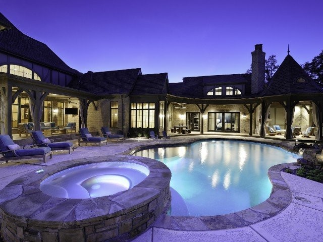Photo of a mid-sized traditional backyard kidney-shaped pool in St Louis with a hot tub and concrete slab.