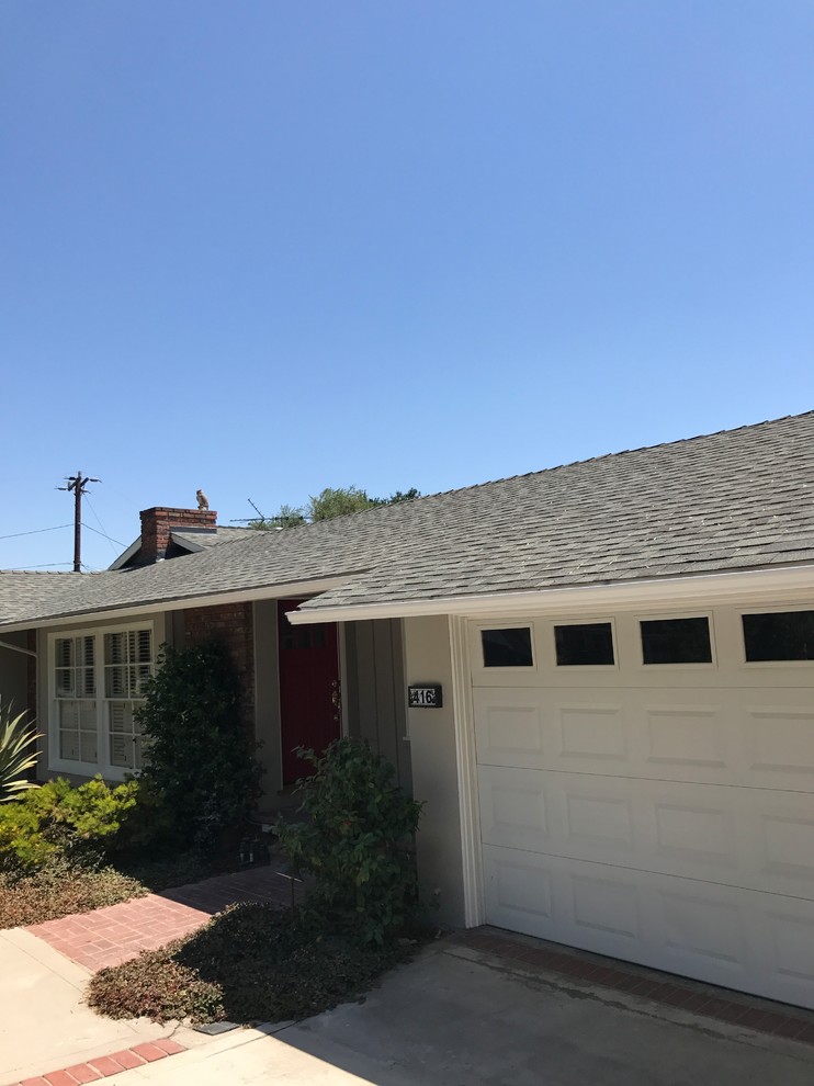 This is an example of a mid-sized transitional one-storey grey house exterior in Los Angeles with wood siding, a hip roof and a shingle roof.