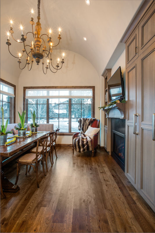 Large eclectic kitchen/dining combo in Salt Lake City with brown walls, medium hardwood floors, a standard fireplace and a plaster fireplace surround.