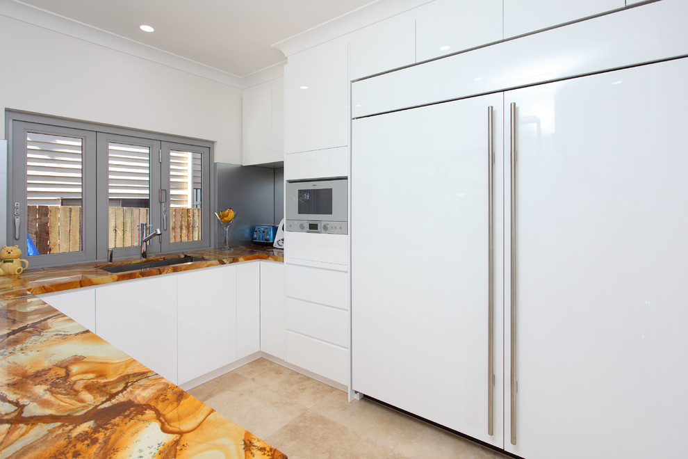 Mid-sized contemporary u-shaped eat-in kitchen in Brisbane with an undermount sink, flat-panel cabinets, white cabinets, quartz benchtops, metallic splashback, metal splashback, stainless steel appliances, porcelain floors, no island, beige floor and multi-coloured benchtop.