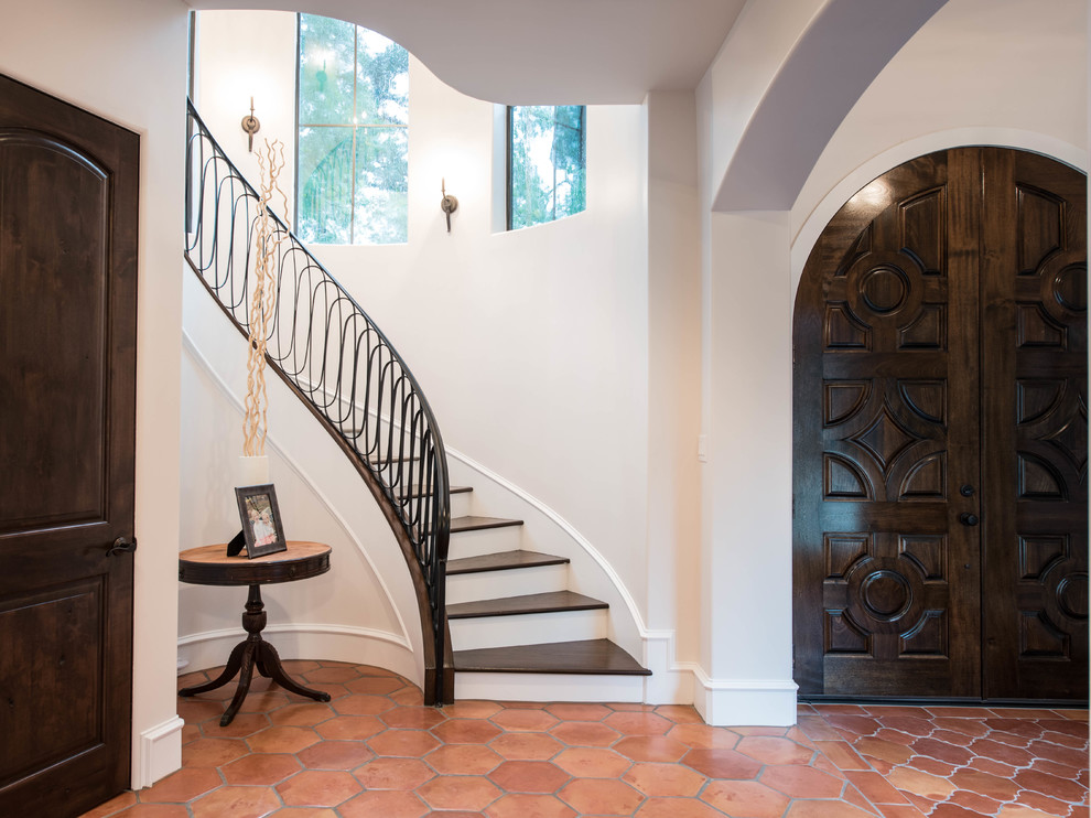 This is an example of a large mediterranean foyer in Dallas with a double front door and a brown front door.