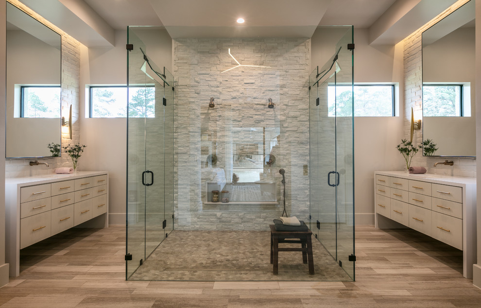 Photo of a mid-sized modern master bathroom with shaker cabinets, white cabinets, a curbless shower, a one-piece toilet, stone tile, white walls, dark hardwood floors, an undermount sink, brown floor, a hinged shower door and white benchtops.