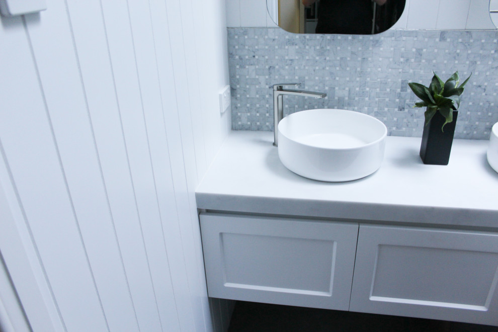 На фото: главная ванная комната среднего размера в стиле модернизм с фасадами в стиле шейкер, белыми фасадами, открытым душем, унитазом-моноблоком, белой плиткой, керамической плиткой, белыми стенами, полом из керамогранита, настольной раковиной, мраморной столешницей, серым полом, открытым душем, белой столешницей, тумбой под две раковины, подвесной тумбой и панелями на стенах с