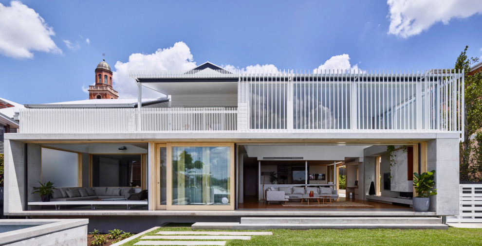 Mittelgroßes, Zweistöckiges Modernes Einfamilienhaus mit Betonfassade, weißer Fassadenfarbe, Satteldach, Blechdach, weißem Dach und Verschalung in Brisbane