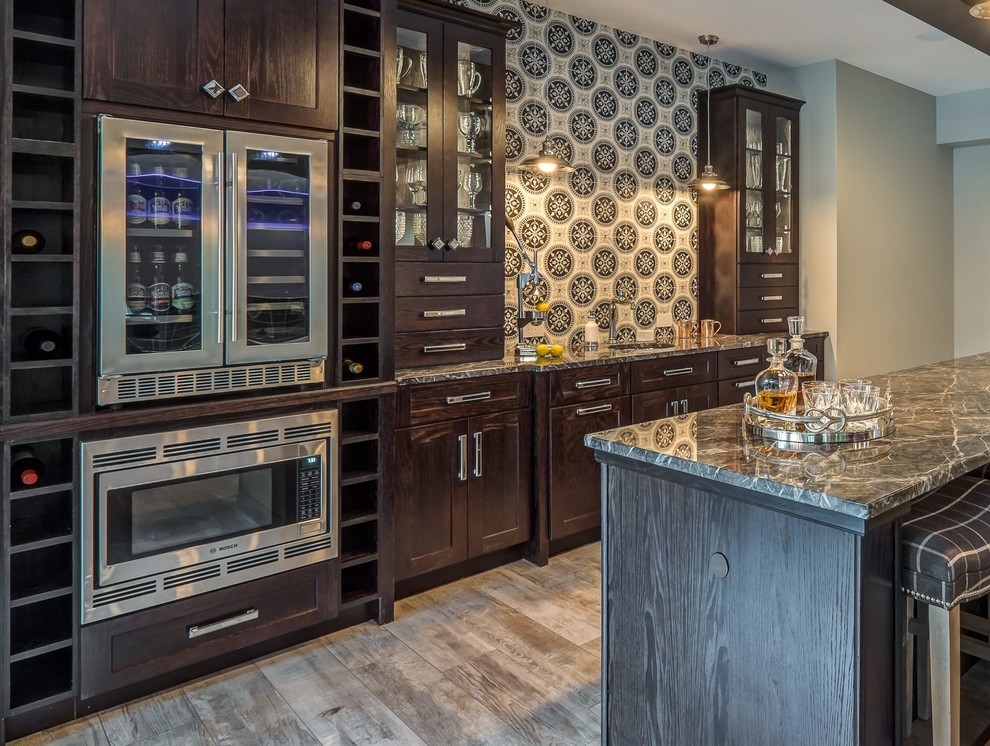Large eclectic galley open plan kitchen in Other with an undermount sink, shaker cabinets, dark wood cabinets, onyx benchtops, multi-coloured splashback, mosaic tile splashback, stainless steel appliances, medium hardwood floors, with island and brown floor.