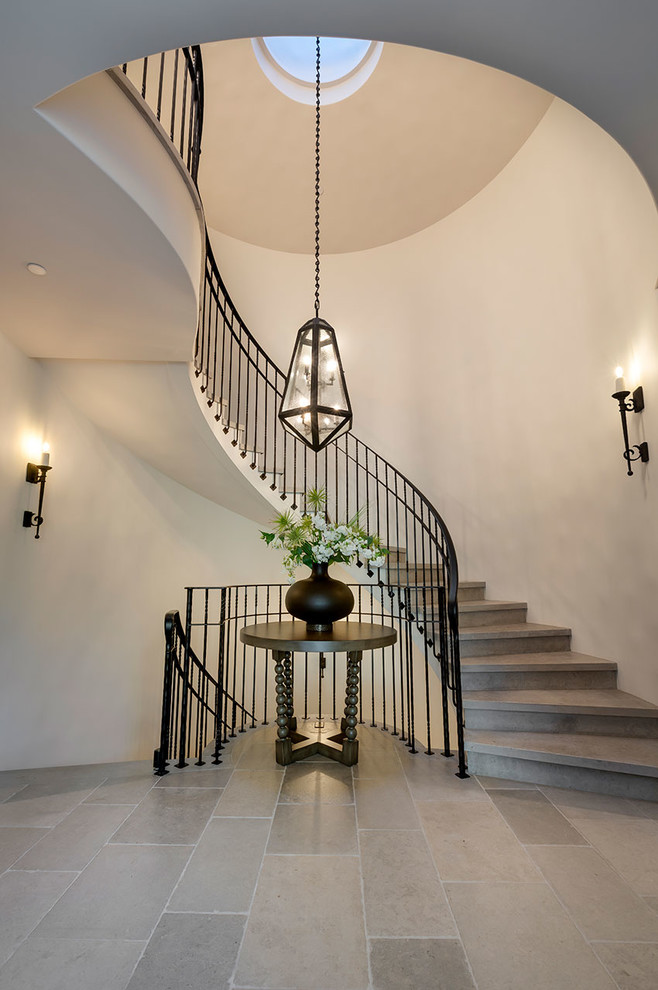 Design ideas for a large mediterranean limestone curved staircase in Other with limestone risers and metal railing.